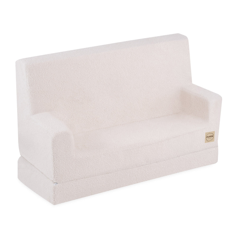 Canapé enfant pliable en mousse avec accoudoirs, revêtement en tissu agneau crème doux et moelleux, modèle Sofa Foldie de Plush Nest.