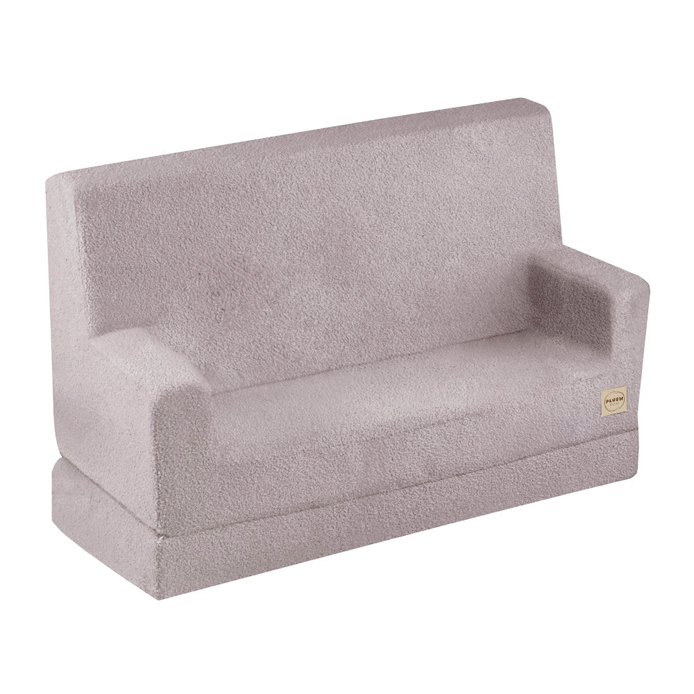 Canapé enfant pliable en mousse avec accoudoirs, revêtement en tissu agneau crème doux et moelleux, modèle Sofa Foldie de Plush Nest.